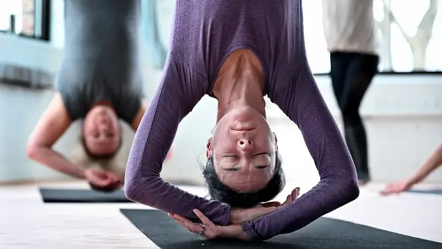 Aerial Yoga student relaxes in an intro pose during one of Earch & Aerial Yoga's Essential beginners class.