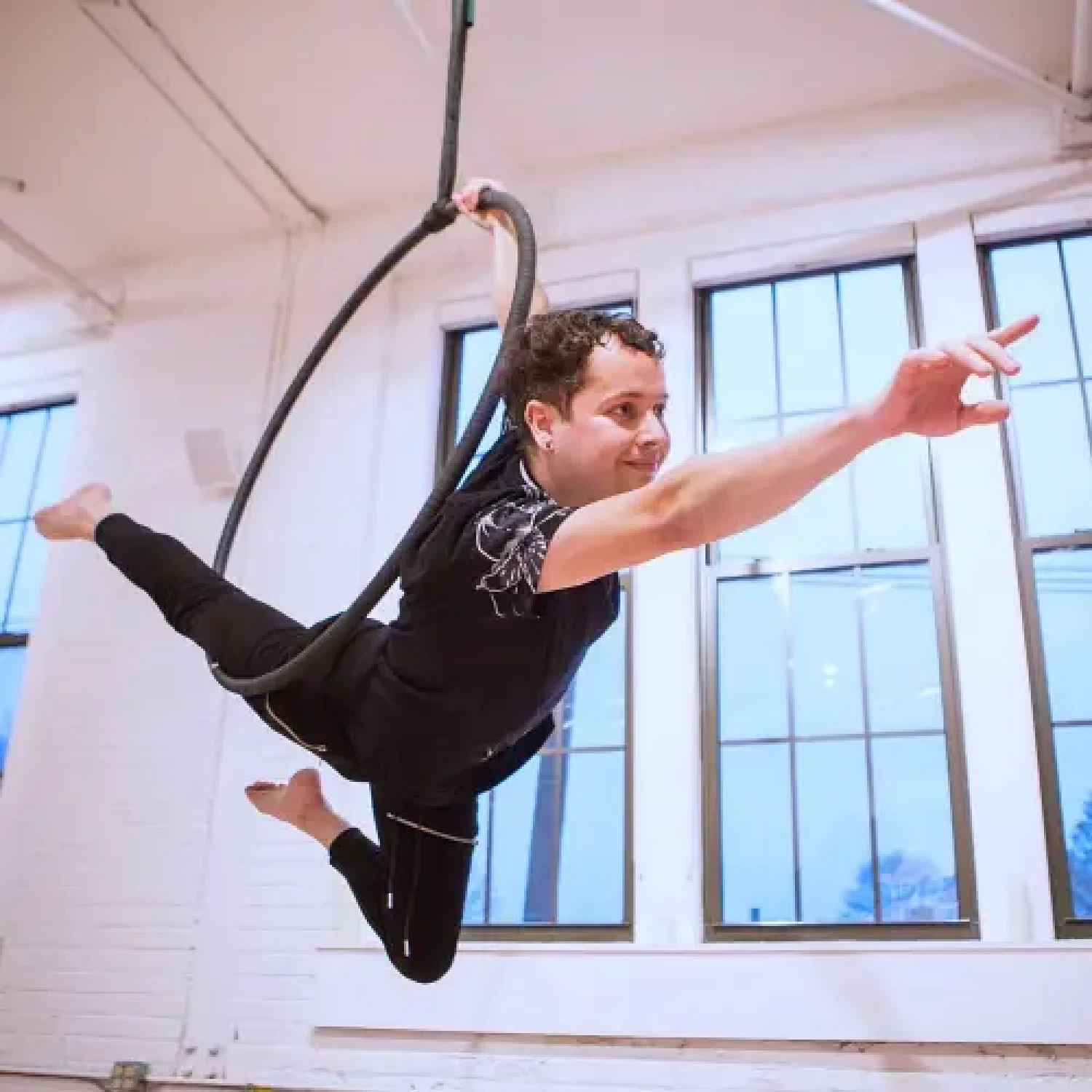 Boston based Lyra instructor Erik Bang extends his one legged mermaid pose while leading an Earth and Aerial advanced Lyra class.