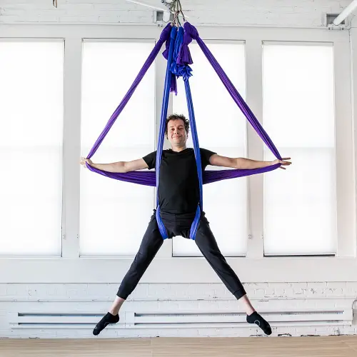 Man performing aerial arts with double sling